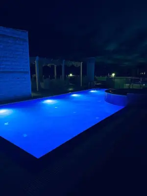 a large swimming pool lit up at night at SF Apartments Lux in Dobra Voda