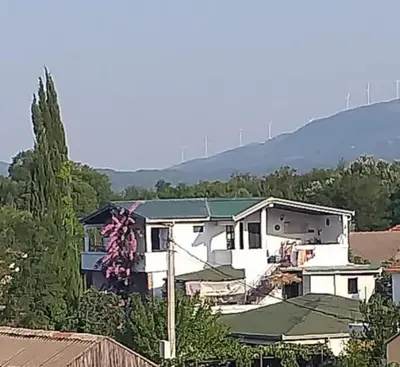 a white house with a green roof at Villa DUDA rooms in Velika Plaža