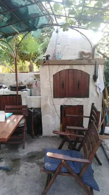 a patio with a table and chairs and a fireplace at Villa DUDA rooms in Velika Plaža