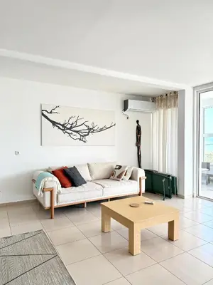a white living room with a couch and a table at Hladna Uvala Minimalist 2 Bedroom Apartman in Bar