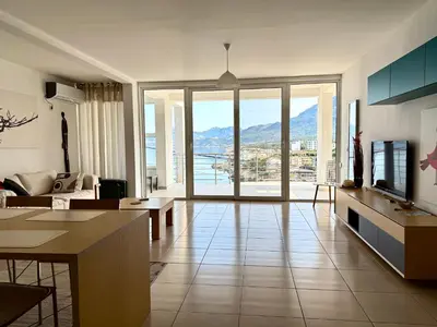 a living room with a couch and a tv at Hladna Uvala Minimalist 2 Bedroom Apartman in Bar