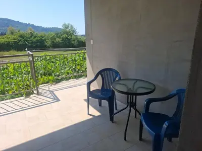 a patio with two chairs and a glass table on a balcony at Apartman Ratko in Budva