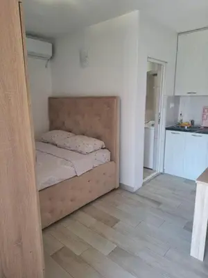 a small bed in a room with a kitchen at Apartman Ratko in Budva