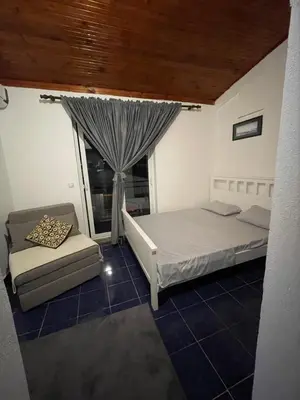 a room with two beds and a couch and a window at Sun & Sea in Ulcinj