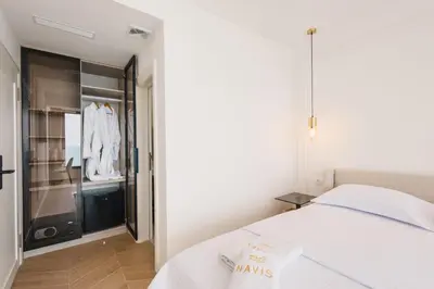 a bedroom with a white bed and a closet at Hotel Navis in Ulcinj