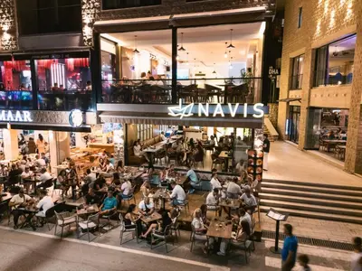 a group of people sitting at tables in a restaurant at Hotel Navis in Ulcinj