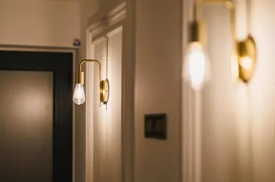 two lights on a wall next to a door at Hotel Navis in Ulcinj