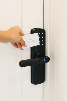 a hand holding a card on a door handle at Hotel Navis in Ulcinj