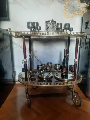 a serving cart with wine glasses and wine bottles on it at Stylish Charm Downtown in Podgorica