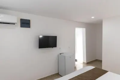 a white room with a tv on a white wall at Dea Apartments in Ulcinj