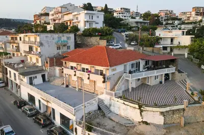 an old building with a red roof on a city street at Dea Apartments in Ulcinj