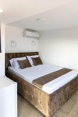 a large bed in a white room with a large mattress at Dea Apartments in Ulcinj
