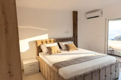 a bedroom with a large bed with a window at Dea Apartments in Ulcinj