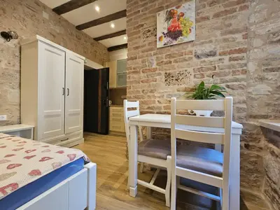 a small kitchen with a table and chairs in a room at Patrik Patrik in Kotor