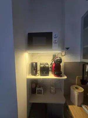 a kitchen with a shelf with a coffee maker on it at Apartman 44 Bečići in Becici