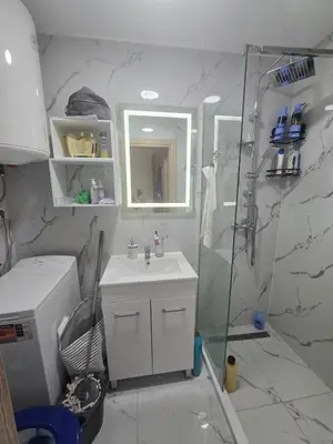 a white bathroom with a shower and a sink at Apartman 44 Bečići in Becici