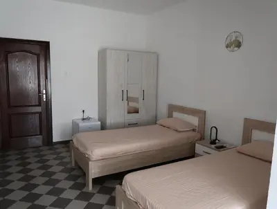 a bedroom with two beds and a checkered floor at Apartmani Krnić in Tuzi