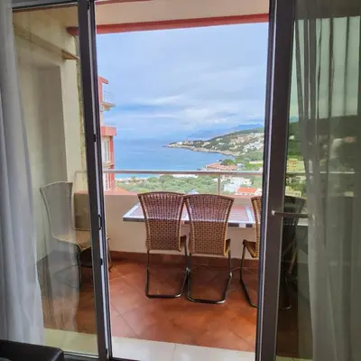 a balcony with a table and chairs and a view of the ocean at Sea & Mountains in Utjeha
