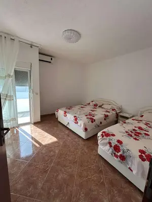 a bedroom with two beds and a window at Aparments Gjeloshi in Donji Štoj