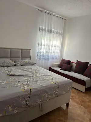a bedroom with a bed and a couch at Aparments Gjeloshi in Donji Štoj