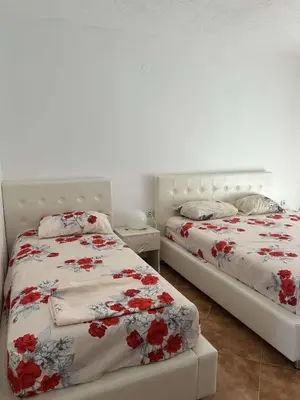 two beds sitting next to each other in a bedroom at Aparments Gjeloshi in Donji Štoj