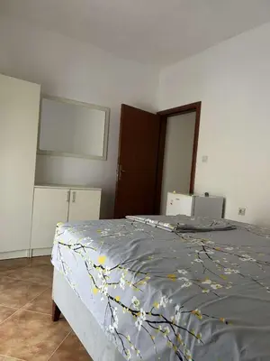 a bedroom with a bed with a blue blanket on it at Aparments Gjeloshi in Donji Štoj