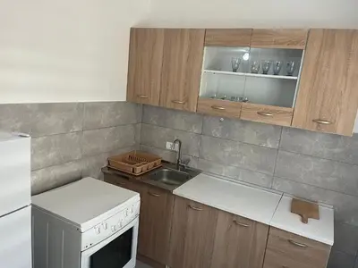 a kitchen with a white stove and a sink at Stan Bijela Kuca in Sutomore