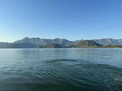 a large body of water with mountains in the background at ORAHOVSTICA TRAIL - Glamping in Dupilo