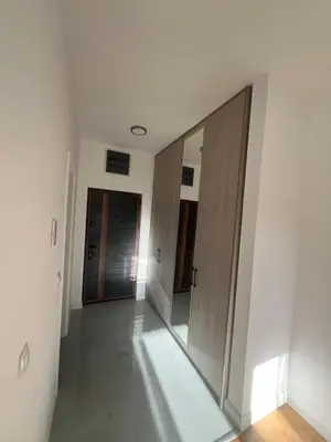 a hallway with two wooden doors and a mirror at SunnyBar in Bar