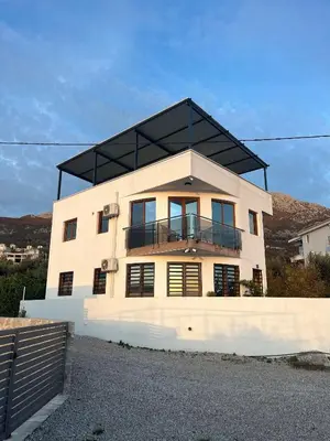 a house with a black roof on top of it at Dobre Voda Montenegro in Dobra Voda