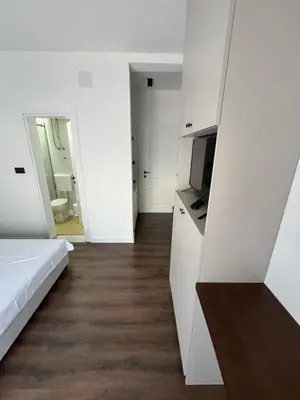 a white room with a bed and a television at Lola Guest House in Budva