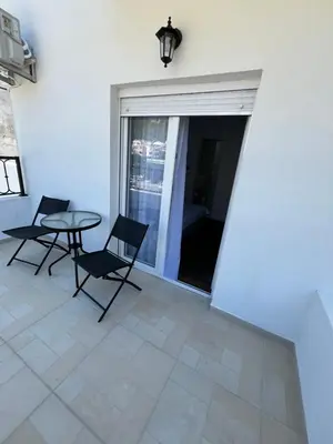 a patio with a table and chairs and a window at Lola Guest House in Budva