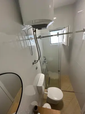 a bathroom with a white toilet and a mirror at Lola Guest House in Budva