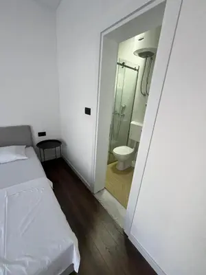 a bedroom with a bed and a bathroom with a toilet at Lola Guest House in Budva