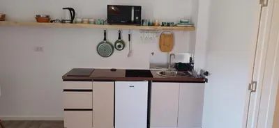 a kitchen with white cabinets and a counter top at KalamperovicApartmani in Bar