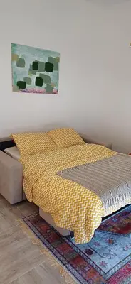 a bed with a comforter and a painting on the wall at KalamperovicApartmani in Bar