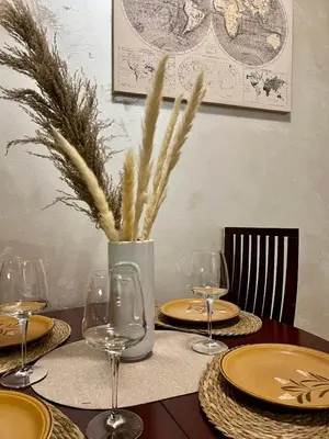 a table with plates and wine glasses on it at Cozy Modern Apartment Podgorica in Podgorica