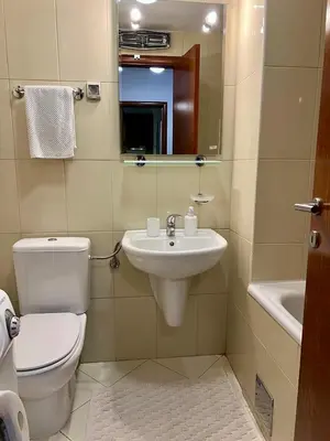 a bathroom with a toilet and a sink and a mirror at Cozy Modern Apartment Podgorica in Podgorica