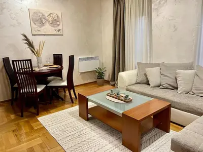 a living room with a couch and a table at Cozy Modern Apartment Podgorica in Podgorica