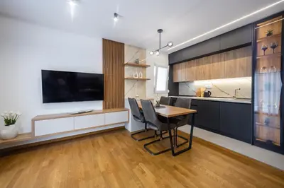 a kitchen with a dining room table and a tv at Fox apartman in Cetinje
