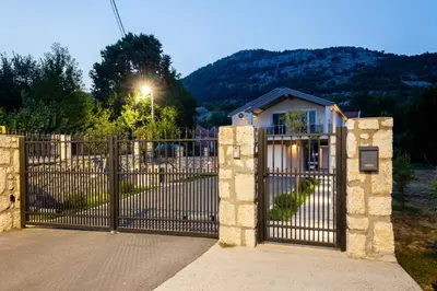 a gate to a house with a mountain in the background at Fox apartman in Cetinje