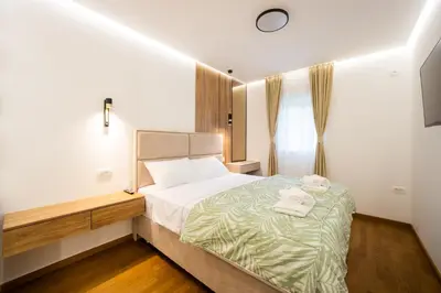a bedroom with a bed with towels on it at Fox apartman in Cetinje