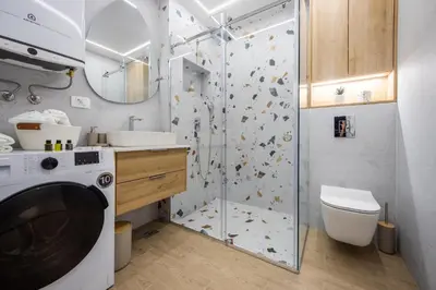 a bathroom with a shower and a washing machine at Fox apartman in Cetinje