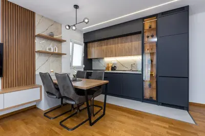a kitchen with a wooden table and black cabinets at Fox apartman in Cetinje