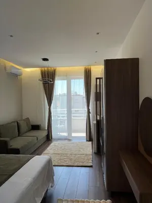 a bedroom with a bed and a couch and a living room at Kurti Apartments in Ulcinj