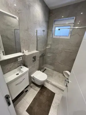a bathroom with a toilet and a sink and a shower at Kurti Apartments in Ulcinj