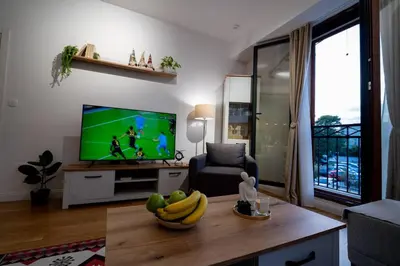 a living room with a television and a bowl of bananas on a table at Gorica Apartment in Podgorica
