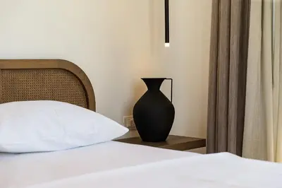 a black vase sitting on a table next to a bed at Zorka in Budva