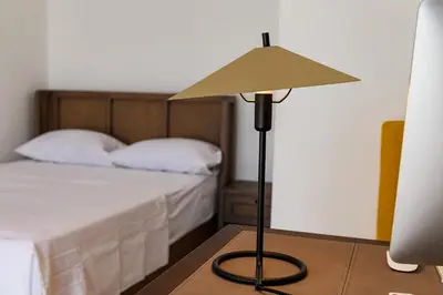 a lamp sitting on a table next to a bed at Zorka in Budva