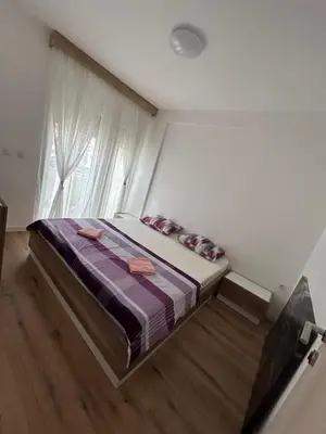 a bedroom with a bed in a room with a window at Sun & Sea Terrace Apartment in Becici